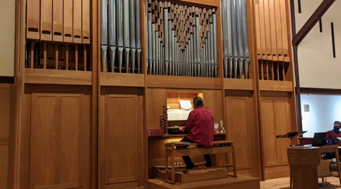 Close view of the Rieger/Pasi organ with Dennis Northway sitting on the bench