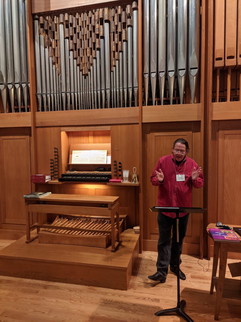 Dennis Northway standing in front of the organ