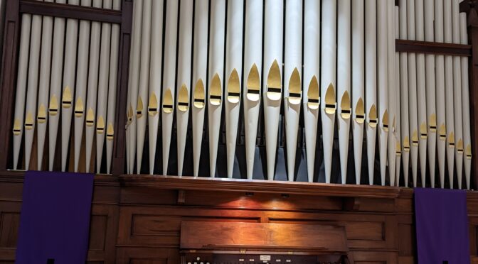 Organ with pipes, key desk, and pedal board