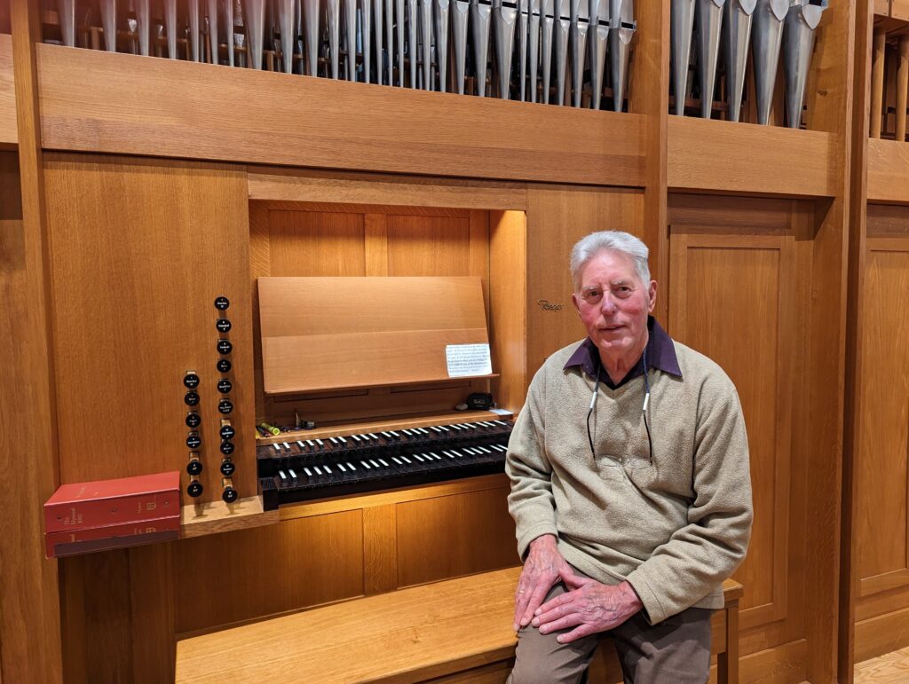 Man sitting on bench in front of organ