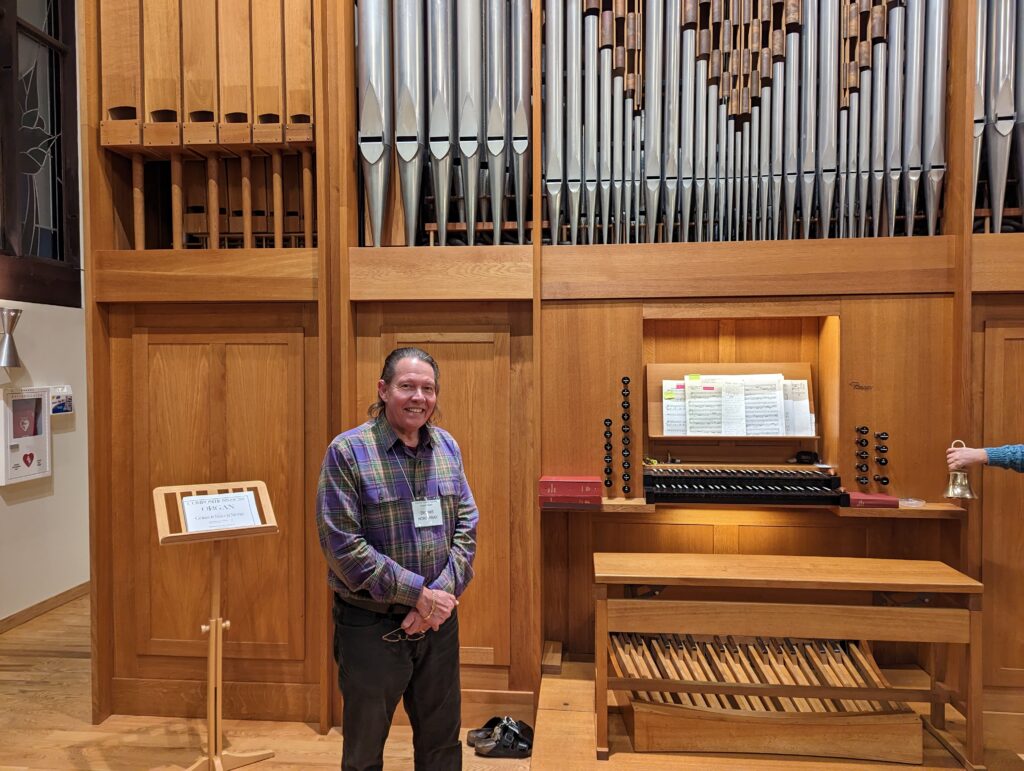 Man standing beside organ