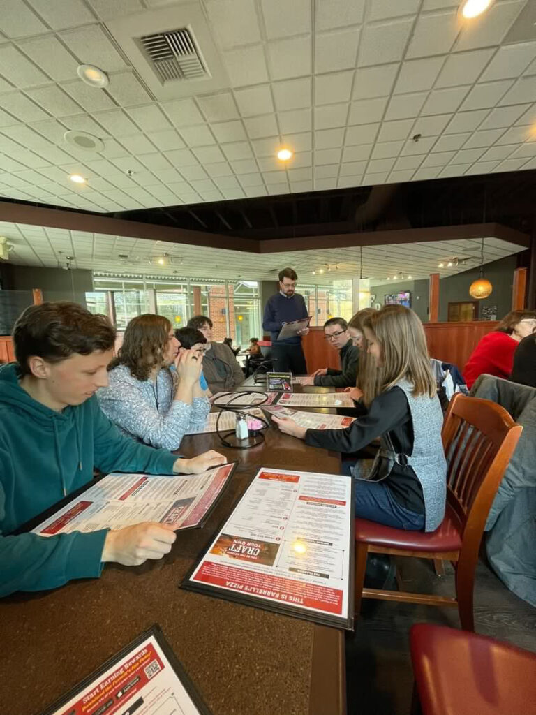 People sitting at table in restaurant with menus