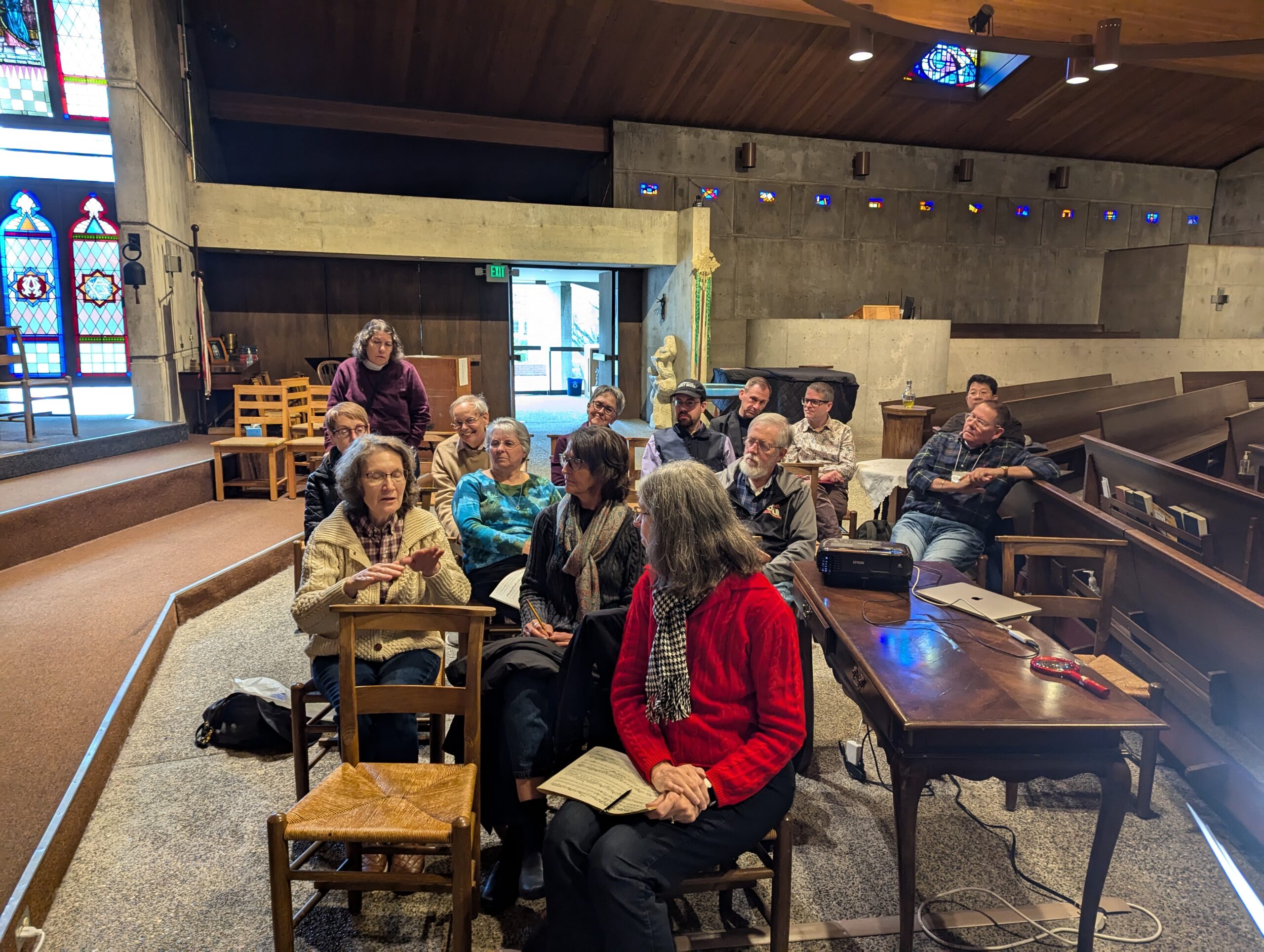 A group of people seated in a church is chatting.
