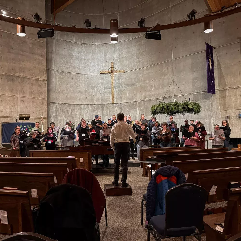 A choir stands at the front of a church.